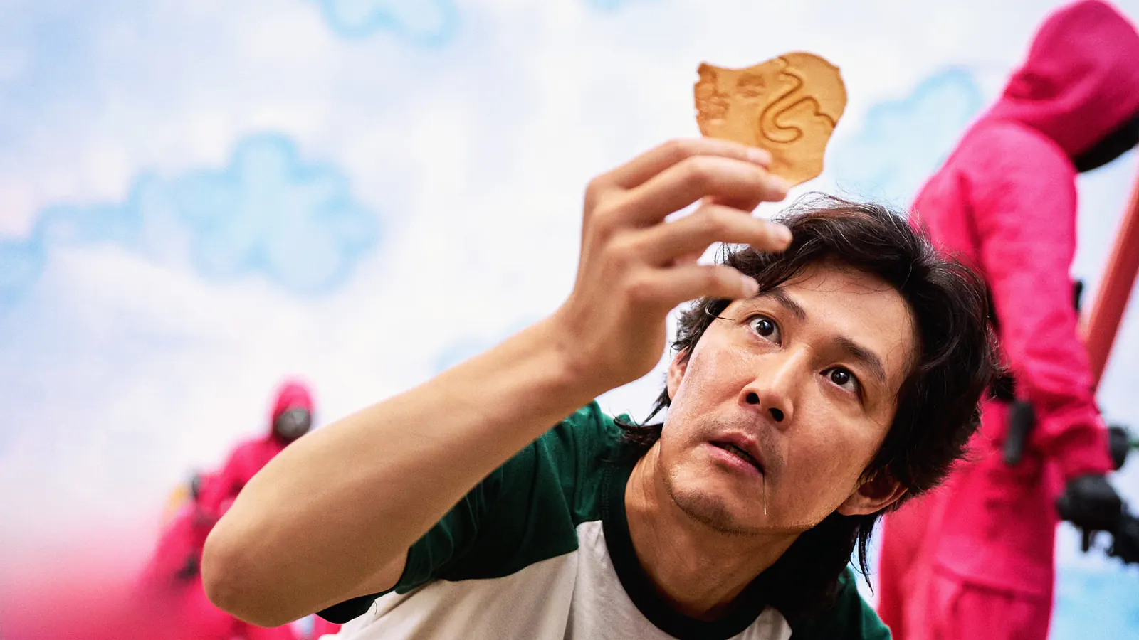 A Squid Game contestant holding a dalgona honeycomb